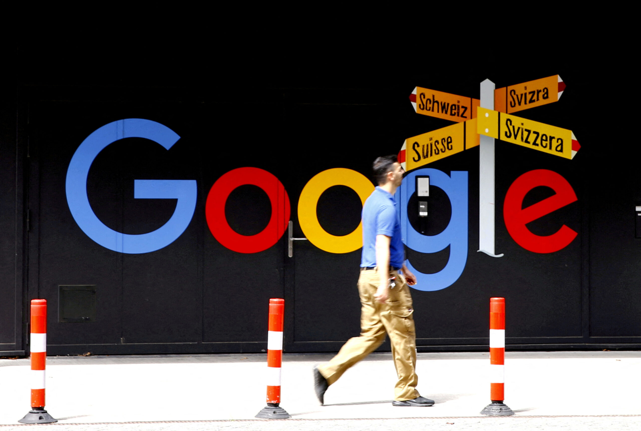 FILE PHOTO: A man walks past a logo of Alphabet Inc's Google in Zurich